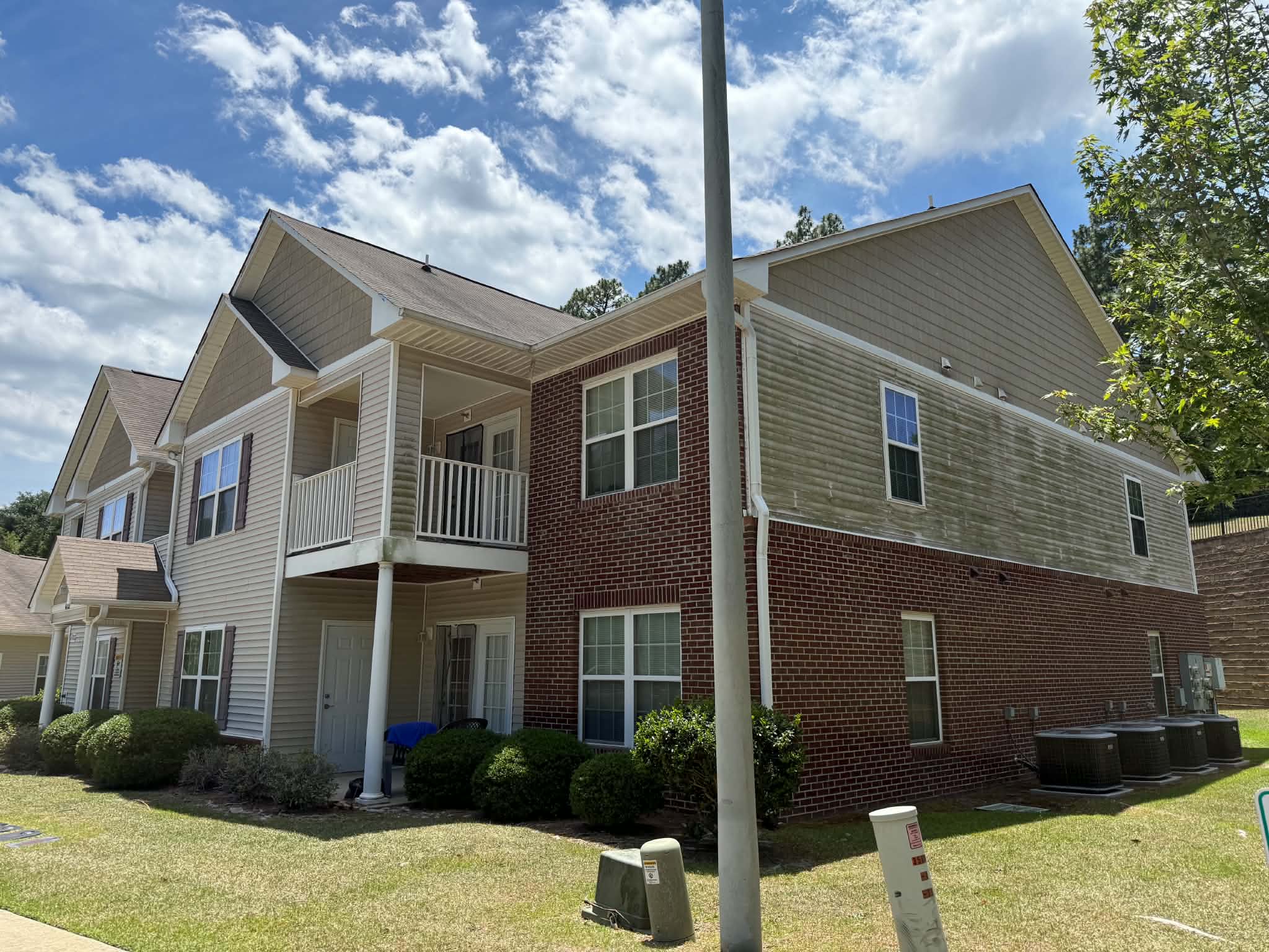 Apartment building exterior siding and brick soft washed by P3